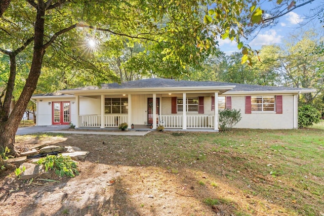 single story home featuring a porch, a front yard, and french doors