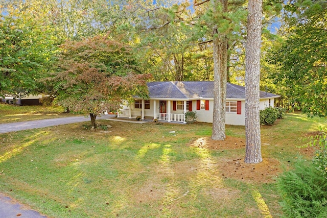 ranch-style home featuring covered porch and a front yard