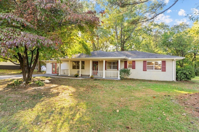 ranch-style home featuring a front lawn and covered porch