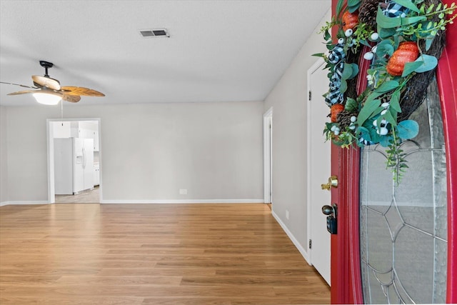 foyer entrance featuring ceiling fan, light hardwood / wood-style flooring, and a textured ceiling