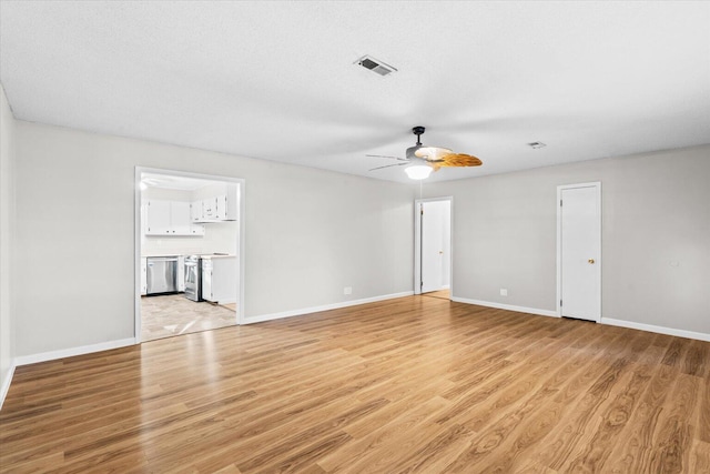 spare room with ceiling fan, light hardwood / wood-style floors, and a textured ceiling