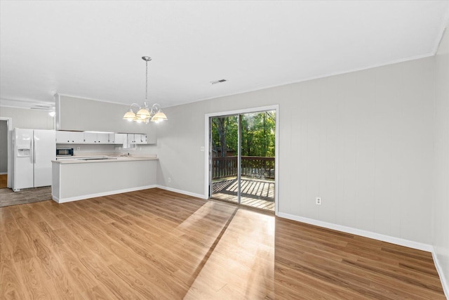 interior space featuring ceiling fan with notable chandelier, light wood-type flooring, and ornamental molding