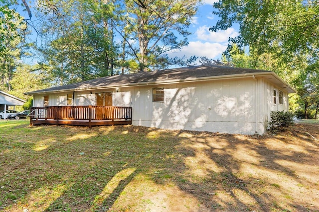 rear view of house with a yard and a deck