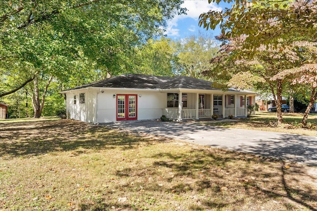 ranch-style home featuring covered porch, french doors, and a front lawn