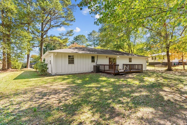 back of house featuring central AC unit, a lawn, and a wooden deck