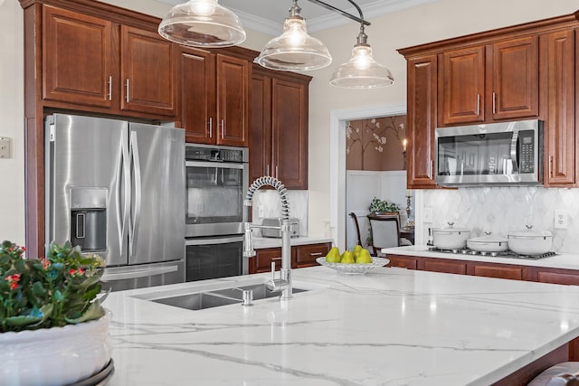 kitchen with backsplash, hanging light fixtures, ornamental molding, appliances with stainless steel finishes, and light stone counters