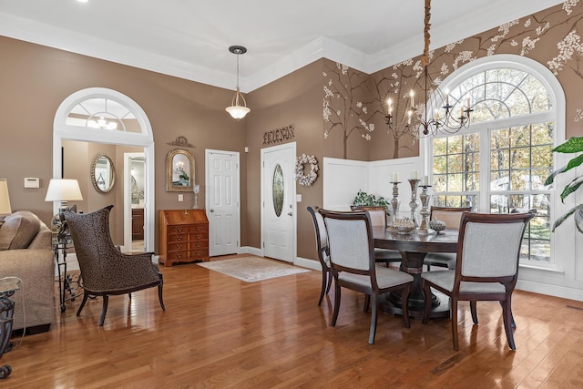 dining space featuring ornamental molding, a chandelier, and wood-type flooring