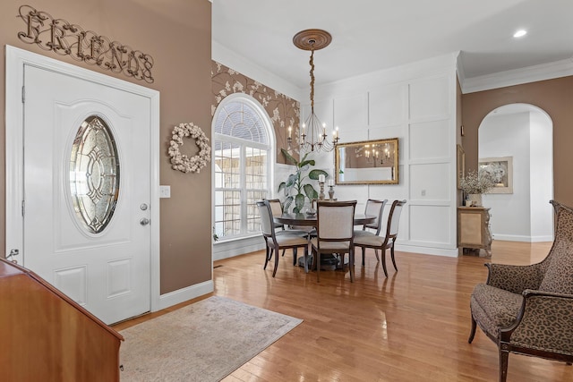 entrance foyer featuring a notable chandelier, crown molding, and light hardwood / wood-style flooring