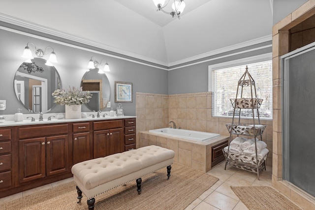 bathroom with vanity, lofted ceiling, tile patterned flooring, ornamental molding, and tiled bath