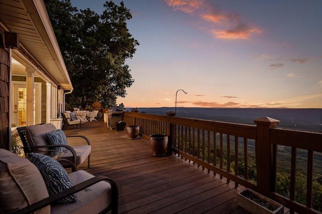 deck at dusk featuring an outdoor living space and a water view