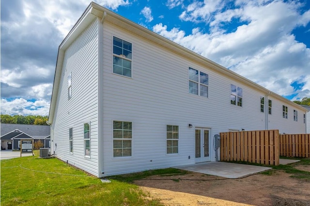 back of property featuring central AC, a patio area, and a lawn