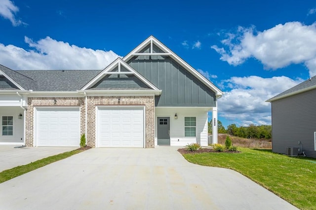 view of front of house featuring central AC unit, a front yard, and a garage