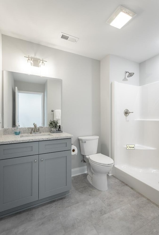 bathroom with a shower, vanity, and toilet