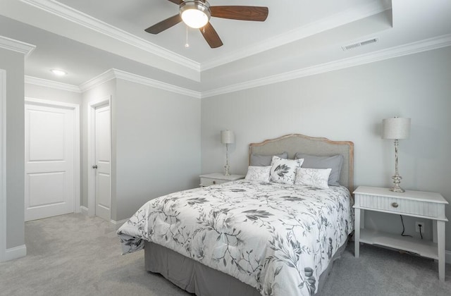 carpeted bedroom featuring ceiling fan, crown molding, and a tray ceiling