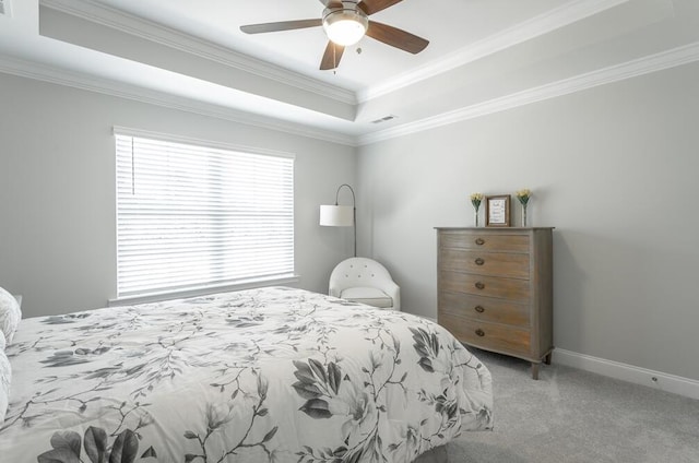 bedroom featuring a tray ceiling, ceiling fan, crown molding, and light colored carpet