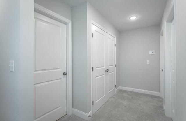 hall with light colored carpet