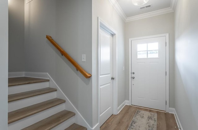 foyer entrance featuring light hardwood / wood-style flooring and ornamental molding