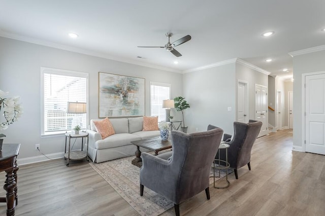 living room with crown molding, light hardwood / wood-style flooring, and ceiling fan