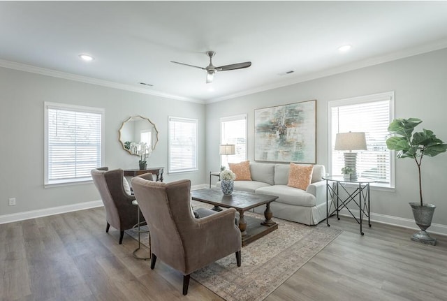 living room featuring ceiling fan, a healthy amount of sunlight, light wood-type flooring, and ornamental molding