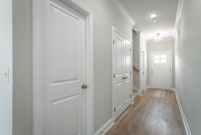 entryway with crown molding and light hardwood / wood-style flooring