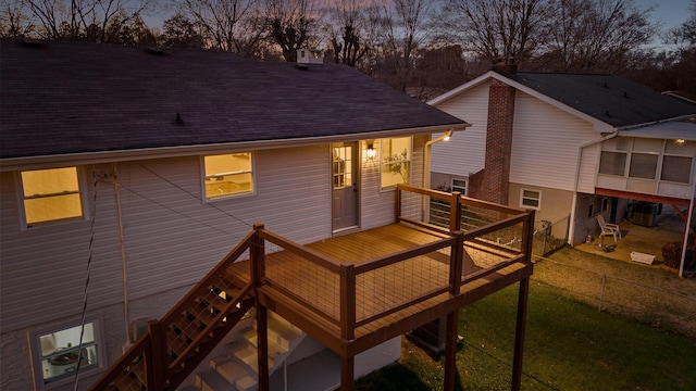 back house at dusk with cooling unit and a deck