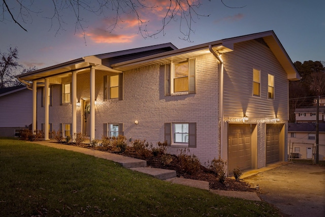 exterior space featuring a garage and a lawn