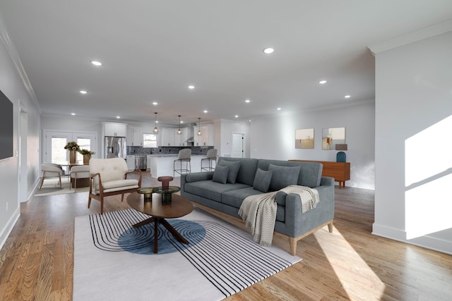 living room featuring crown molding and light hardwood / wood-style floors