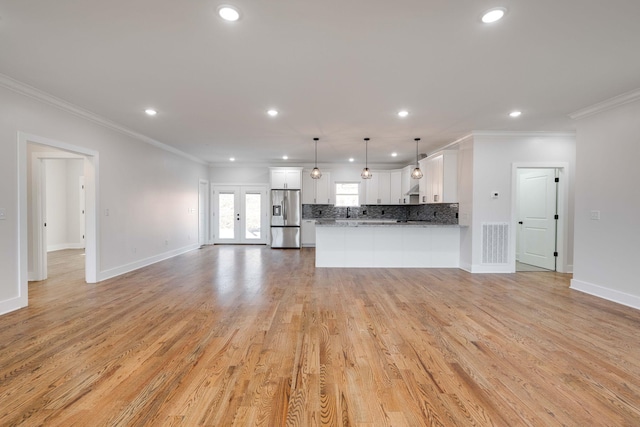 unfurnished living room featuring light wood-type flooring, french doors, and ornamental molding