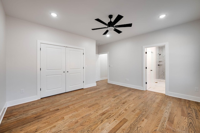 unfurnished bedroom featuring light wood-type flooring, ceiling fan, a closet, and ensuite bath