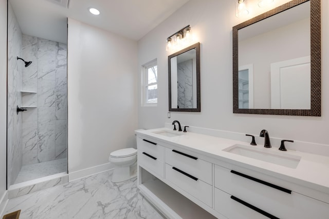 bathroom with toilet, vanity, and tiled shower