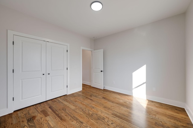 unfurnished bedroom with a closet and light wood-type flooring