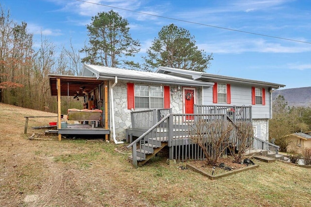 view of front facade featuring a wooden deck and a front lawn