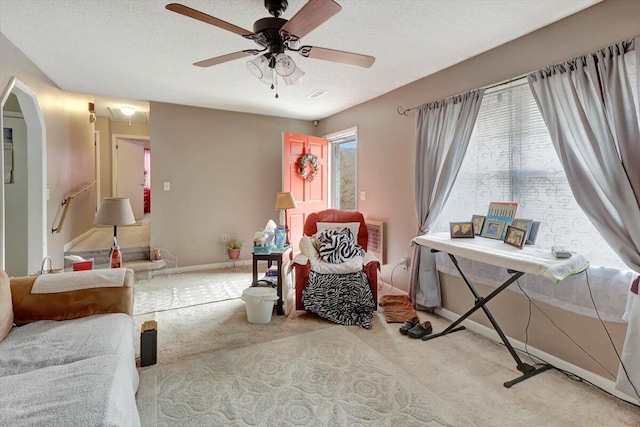 sitting room with a healthy amount of sunlight, light carpet, and a textured ceiling