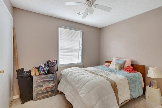 bedroom featuring multiple windows, light carpet, a textured ceiling, and ceiling fan