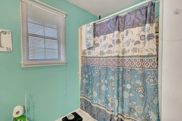 bathroom featuring tile patterned flooring and a textured ceiling