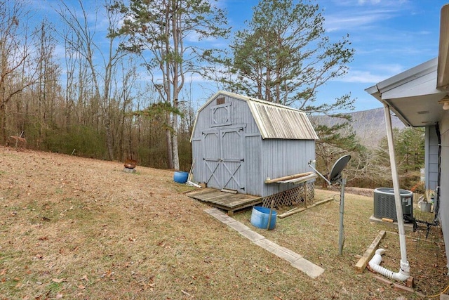 view of outdoor structure featuring cooling unit and a lawn