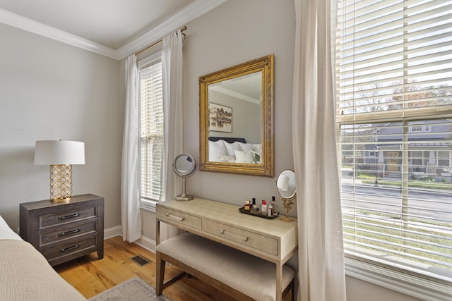 sitting room featuring light wood-type flooring, a wealth of natural light, and ornamental molding