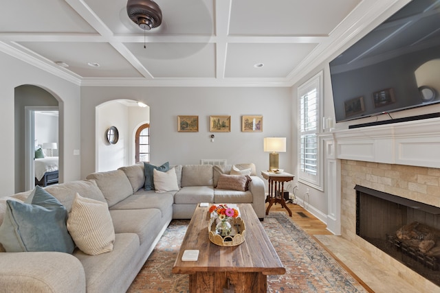 living room featuring beam ceiling, ornamental molding, coffered ceiling, and light hardwood / wood-style flooring