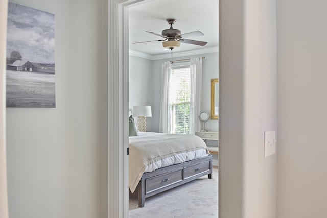 carpeted bedroom with ceiling fan and ornamental molding