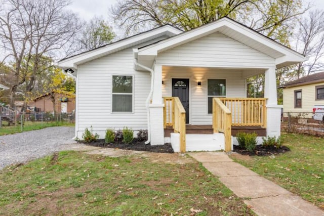 bungalow-style house featuring covered porch and a front lawn