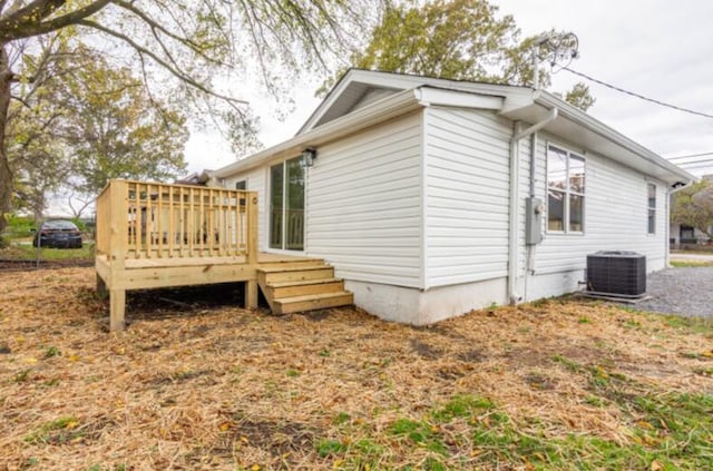 view of property exterior featuring central air condition unit and a deck