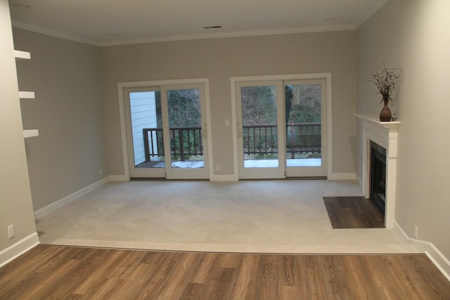 unfurnished living room with ornamental molding and carpet