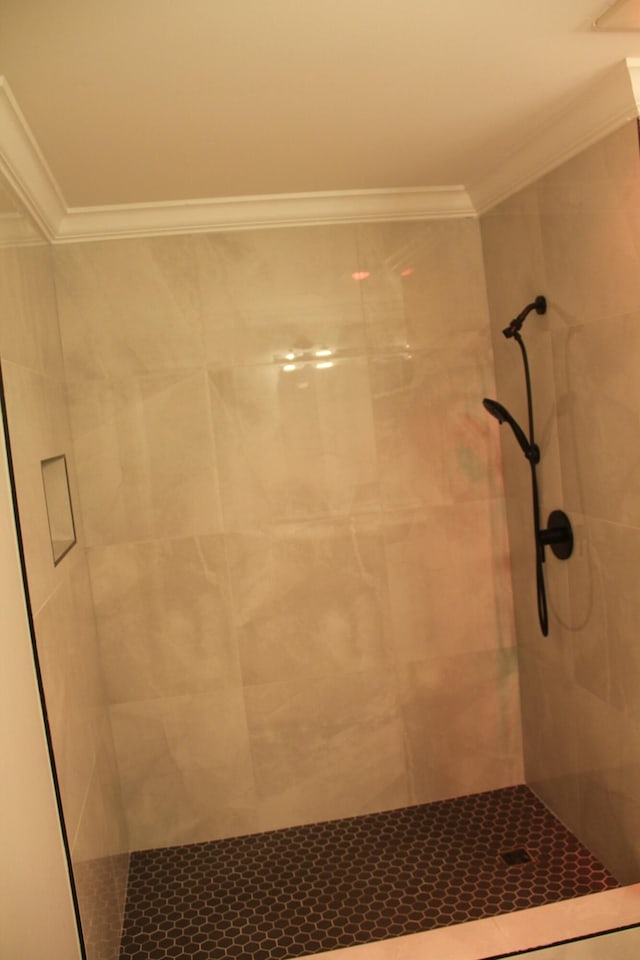 bathroom featuring tiled shower and crown molding