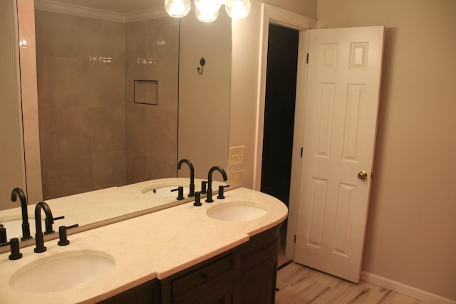 bathroom with crown molding, vanity, and hardwood / wood-style flooring