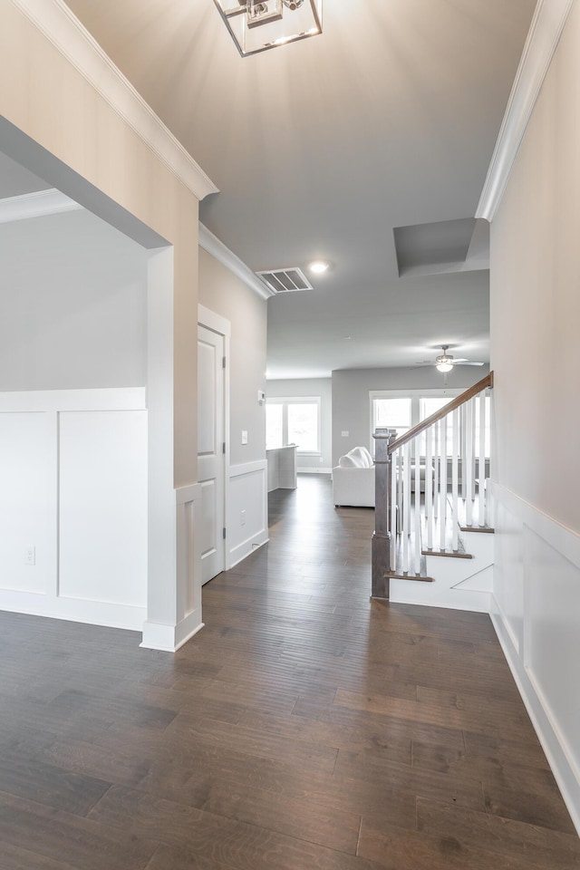 corridor featuring dark wood-type flooring and ornamental molding