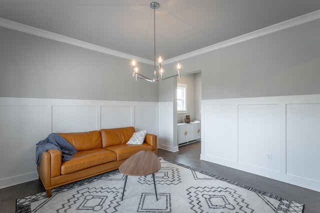 living room featuring dark hardwood / wood-style flooring, a chandelier, and ornamental molding