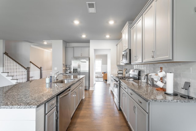 kitchen featuring stainless steel appliances, a center island with sink, and sink