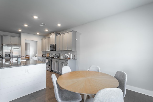 dining room featuring sink and dark hardwood / wood-style flooring