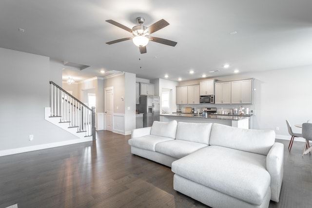 living room featuring ceiling fan, dark hardwood / wood-style flooring, crown molding, and sink