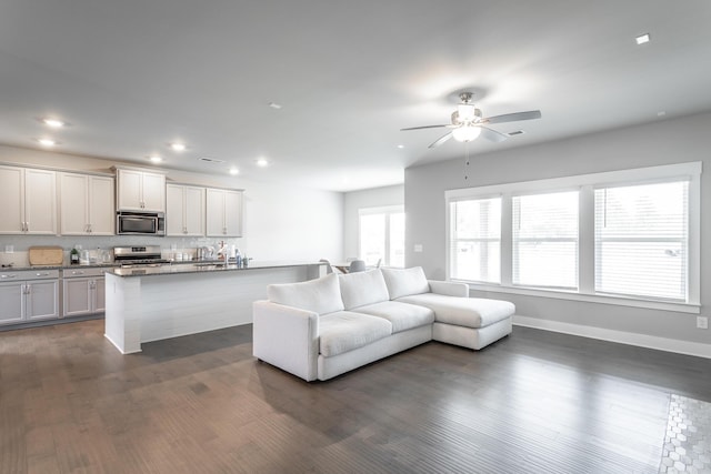 living room with ceiling fan and dark hardwood / wood-style floors